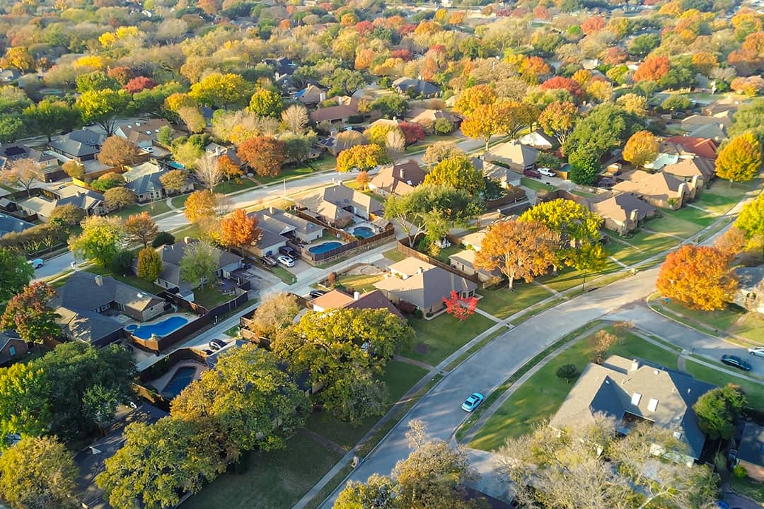 An aerial view of a suburban residential neighborhood during autumn season.